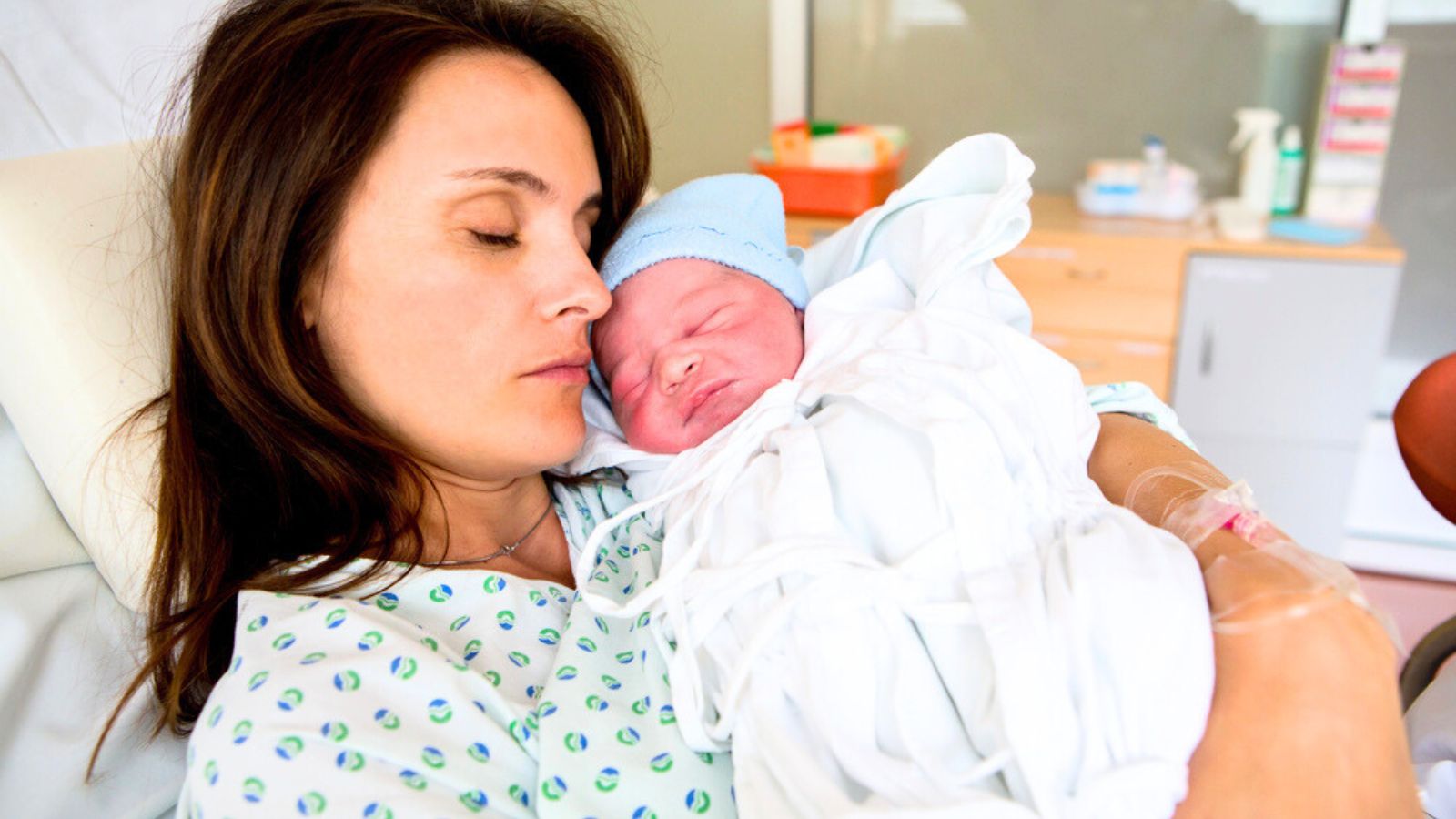 Happy mom, having her baby skin to skin first seconds after birth