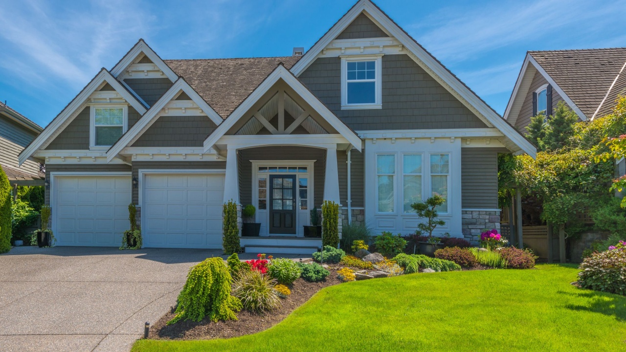 Big custom made luxury house with nicely landscaped front yard and long and wide driveway to garage in the suburb of Vancouver, Canada.