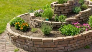 herb spiral in the garden with herbs and flowers